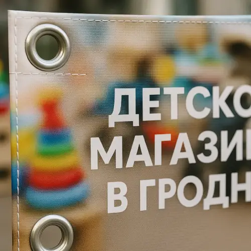 Баннер для детского магазина в Гродно — крупный план люверсов и прошитых краев, качество крепления