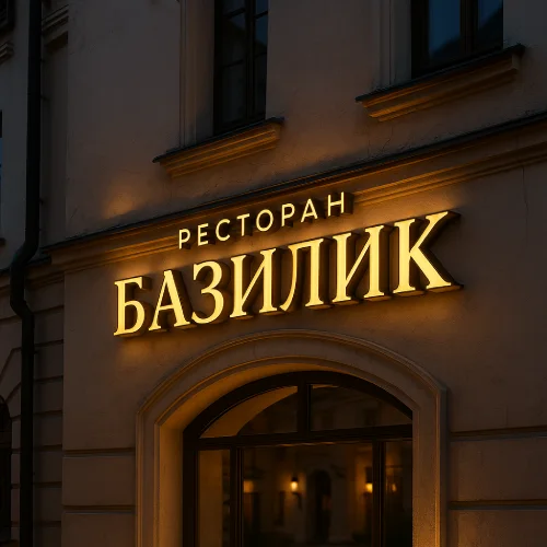 Вывеска ресторана «Базилик» в Минске — объемные буквы под золото с мягкой теплой подсветкой на историческом фасаде